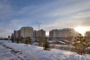 a city in the snow with tall buildings at Akbulak Town Lux in Astana