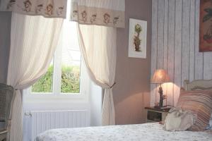 a bedroom with a bed and a window at Chambres d'Hôtes Le Petit Nailly in Magny-les-Hameaux