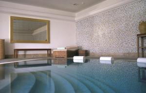 a swimming pool in a room with a wall of tiles at Anassa in Polis Chrysochous