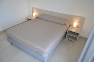 una camera da letto con un letto con due luci sopra di Crystal B&B a Dormelletto