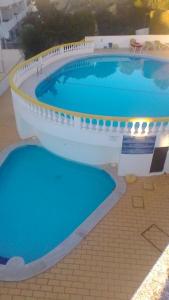uma grande piscina com água azul em Appartement D'Or em Carvoeiro