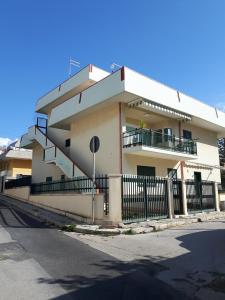 a white building with stairs and a fence at BOBO' in Marina di Ragusa