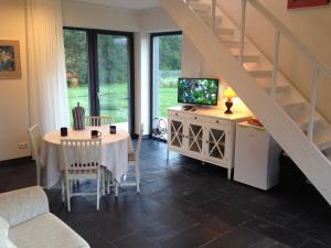 a living room with a table and a staircase at Piesta Kuusikaru riverside cottage in Soomaa region in Kullimaa