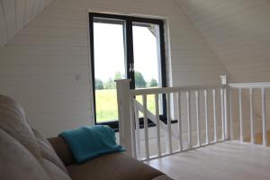 a living room with a couch and a window at Piesta Kuusikaru riverside cottage in Soomaa region in Kullimaa