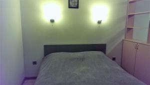 a bedroom with a bed and two lights on the wall at Izmir Apartment in Baku