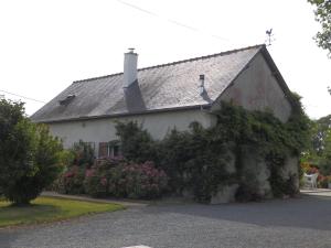 une maison blanche avec des fleurs devant elle dans l'établissement Gîte La MER, à Commes