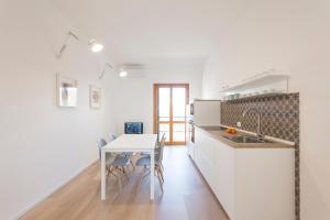 a kitchen with a sink and a table with chairs at BOBO' in Marina di Ragusa