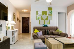 a living room with a couch and a table at weforyou near the beach TWO bedrooms in Pueblo Evita in Benalmádena