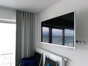 um quarto com uma grande janela e uma televisão na parede em Haus zur Mole - Morgenstern em Grossenbrode