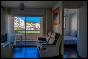- un salon avec un canapé et une chambre dans l'établissement Résidence la corvette, à Sète