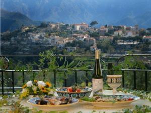 einen Tisch mit einer Flasche Wein und Schüsseln zum Essen in der Unterkunft Albergo La Margherita in Scala