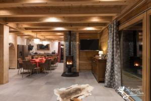 a dining room with a table and a fireplace at Le Domaine des Fleurs - Chalet La Reine des Prés in Gérardmer