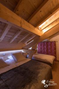 a large bed in a room with wooden ceilings at Le Domaine des Fleurs - Chalet La Reine des Prés in Gérardmer
