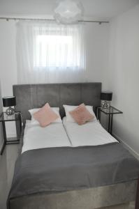 1 dormitorio con 1 cama con 2 almohadas en Apartament Wilenska, en Mrągowo