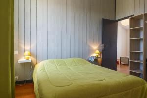 a bedroom with a bed with a yellow blanket on it at Villa Orkagna in Perros-Guirec