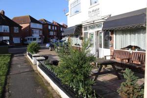 un banco de madera sentado frente a un edificio en The Mayfair, en Skegness