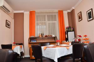 a dining room with a table and chairs and a window at Hotel Boutique Monaco in Bucharest