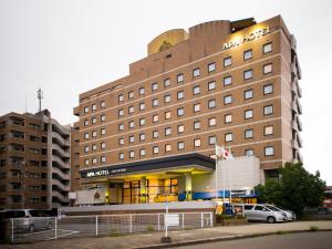 un edificio de hotel con coches estacionados frente a él en APA Hotel Kagadaishoji-ekimae, en Kaga