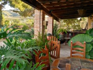 patio z krzesłami i stołem oraz roślinami w obiekcie Casa Rural LOS CORTESES w mieście Los Díaz