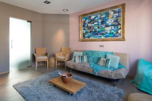 a living room with a couch and a painting on the wall at App De Panne 2 in De Panne