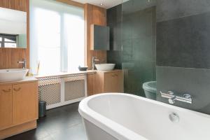 a bathroom with a tub and a sink and a toilet at App De Panne 2 in De Panne