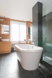 a large bathroom with a large tub and a shower at App De Panne 2 in De Panne