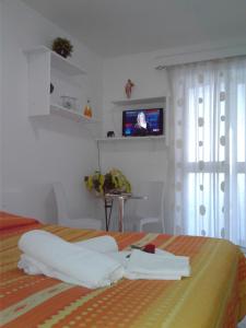 a bedroom with a bed with a television on the wall at GRANELLO di Sabbia in Peschici