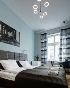 een slaapkamer met een bed en een groot raam bij Grace Apartments in Krakau