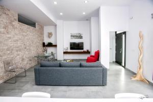 a living room with a blue couch and a red chair at La Pandorga in Sanlúcar de Barrameda