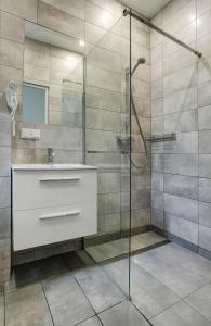 a bathroom with a sink and a shower at Grace Apartments in Krakow