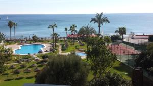 a view of a resort with a pool and the ocean at TORREMOLINOS CARIHUELA 1ª LINEA PLAYA in Torremolinos