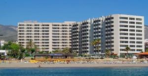 un gran hotel en una playa con un gran edificio en TORREMOLINOS CARIHUELA 1ª LINEA PLAYA, en Torremolinos