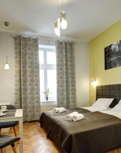 a bedroom with a bed with two towels on it at Grace Apartments in Krakow
