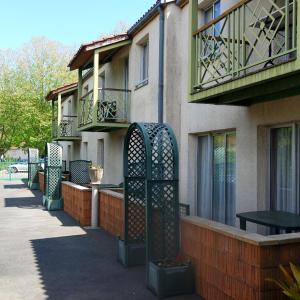 een gebouw met een hek naast een balkon bij Appart'hôtel Le Tulipier in Cransac