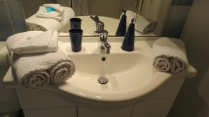 a white bathroom sink with towels on it at B&B Andrey in Marly-le-Grand