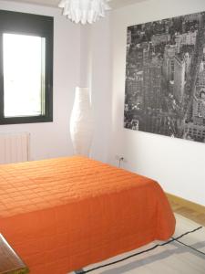 a bedroom with an orange bed and a vase at Apartamento Agarimo - La tranquilidad de una isla de menos de 5000 habitantes in Isla de Arosa