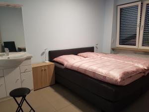 Schlafzimmer mit einem schwarzen Bett und einem Waschbecken in der Unterkunft Hostel Gästehaus zum Padre in Goch