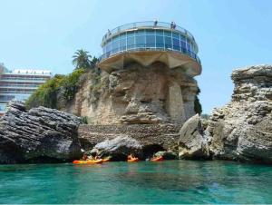 a group of people in kayaks in the water near a building at Apartamento Nerja Beach in Nerja