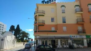 a tall building with cars parked in front of it at Apartamento Nerja Beach in Nerja