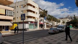 a man is crossing a street in a city at Apartamento Nerja Beach in Nerja