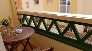 a balcony with a wooden table and a window at Apartamento Nerja Beach in Nerja