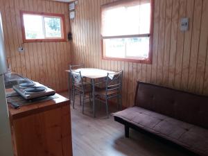 a living room with a table and a couch at Cabañas El Leñador in Coihaique