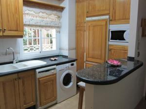 a kitchen with a washing machine and a sink at Apartamento Nerja Beach in Nerja