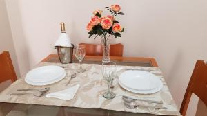 a table with two plates and a vase with flowers at Apartamento Nerja Beach in Nerja