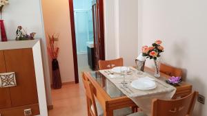 a dining room with a table and chairs with flowers on it at Apartamento Nerja Beach in Nerja