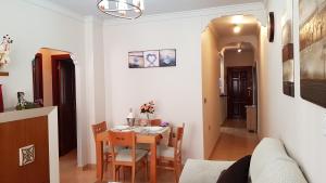 a dining room and living room with a table and chairs at Apartamento Nerja Beach in Nerja
