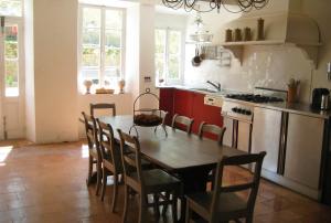 Il comprend une cuisine avec une table et des chaises en bois. dans l'établissement Maison vigneronne, à Montlaur