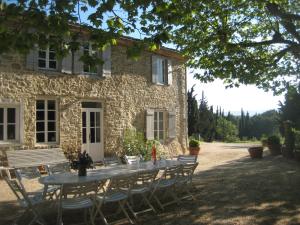 a table and chairs in front of a stone building at Maison vigneronne in Montlaur