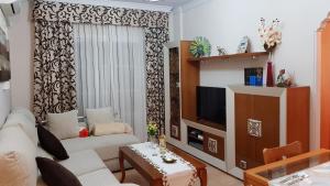 a living room with a couch and a tv at Apartamento Nerja Beach in Nerja