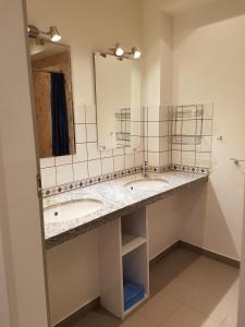 a bathroom with two sinks and a mirror at Hostel Gästehaus zum Padre in Goch